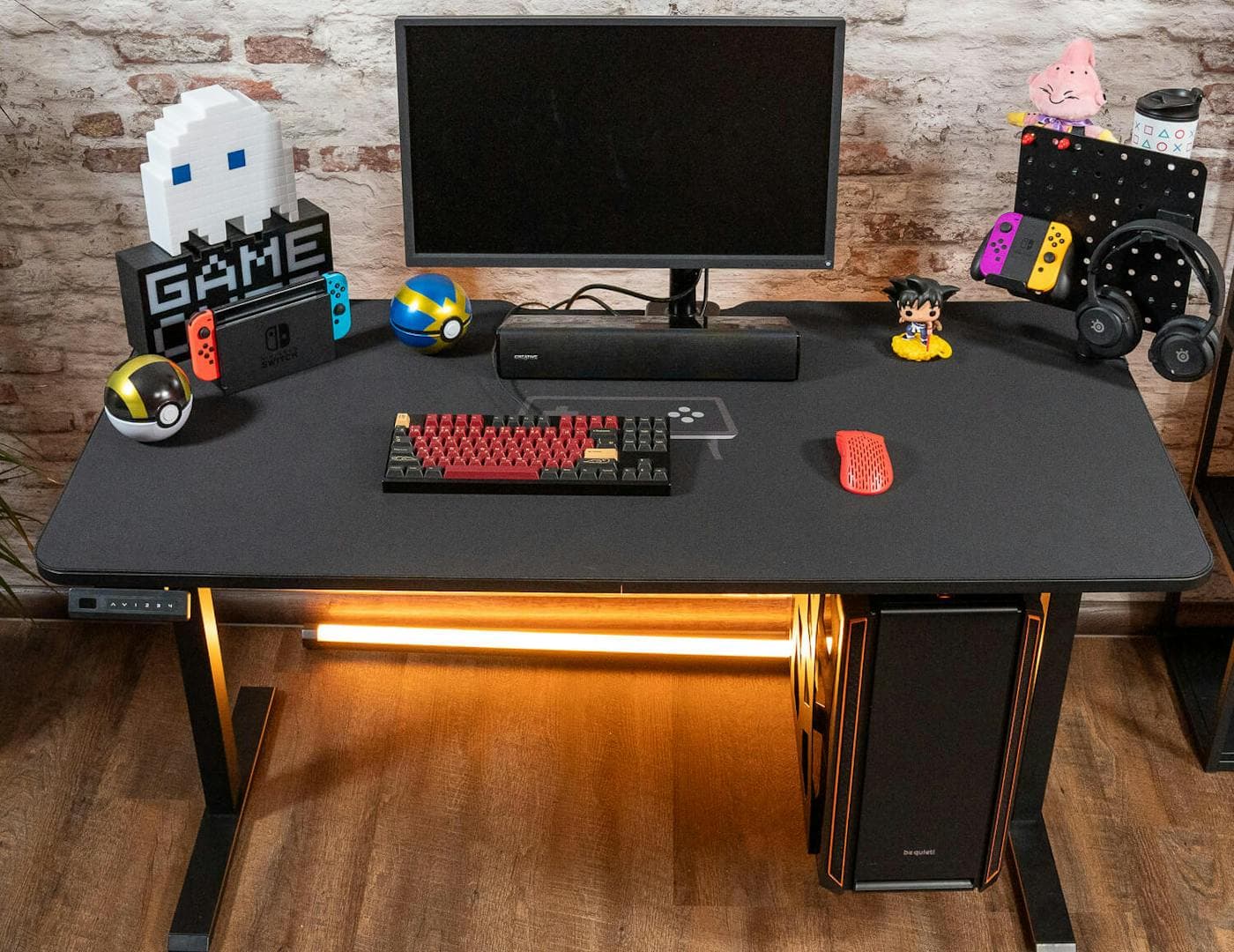 Un setup gaming complet sur un Leetdesk, avec un deskpad noir et un éclairage RGB en dessous, mettant en valeur divers accessoires et un clavier placé sur le mauspad pour un look propre et professionnel.